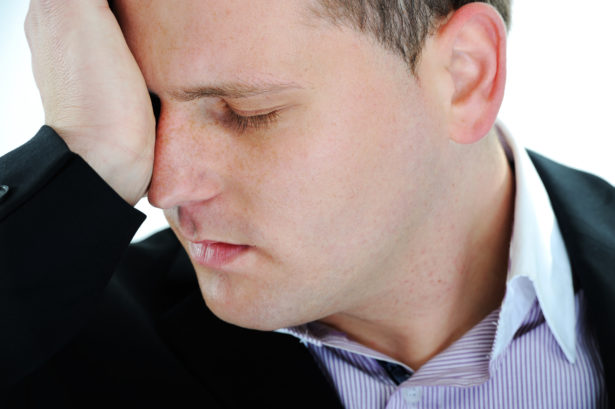Man suffering from migraine or headache over white